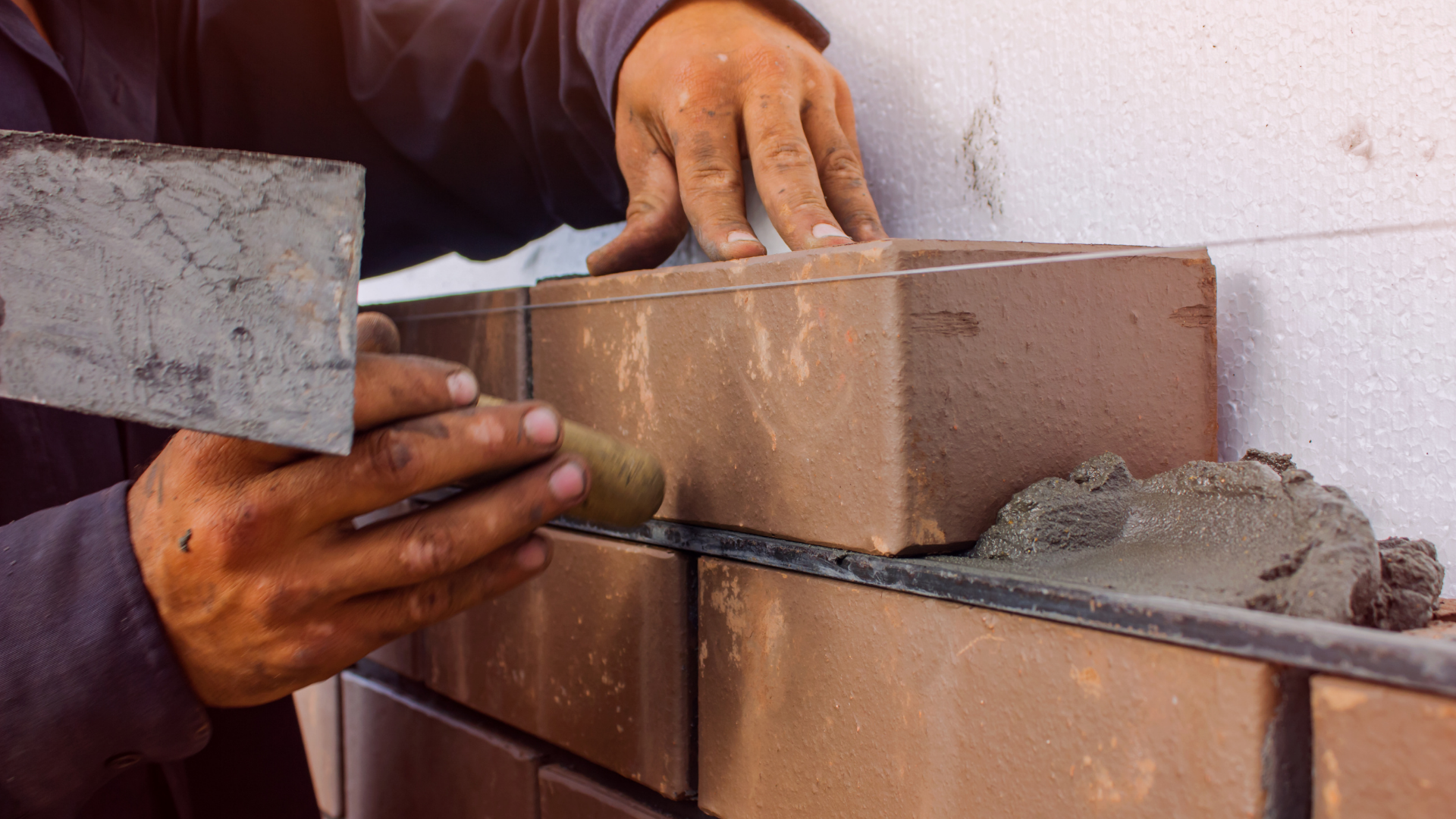 Bricklayer aligning brickwork