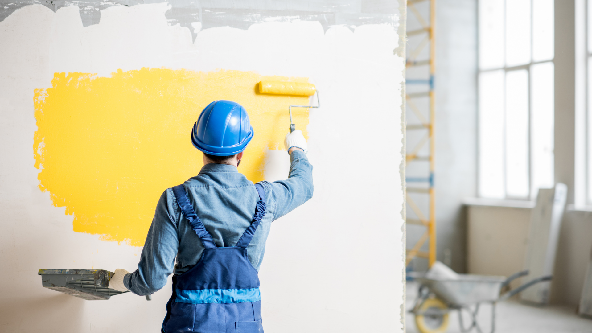 Construction painter applying yellow paint